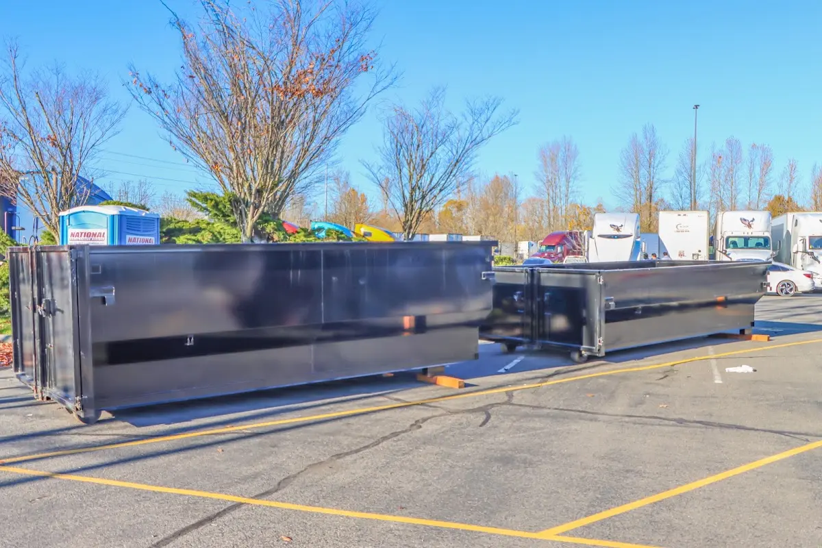 Professional dumpster rental service with roll-off container on residential driveway in Grand Haven